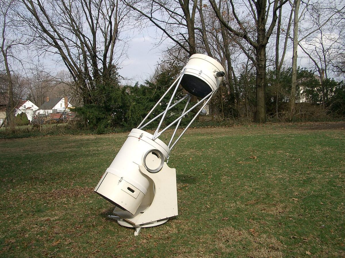 Telescópio refletor do tipo Dobson com tubo em treliça instalado num jardim