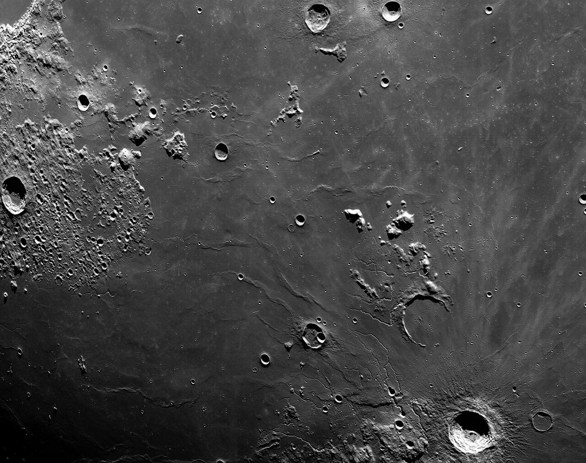Miniatura: Planície lunar com pequenas crateras e cristas fotografada a partir de órbita