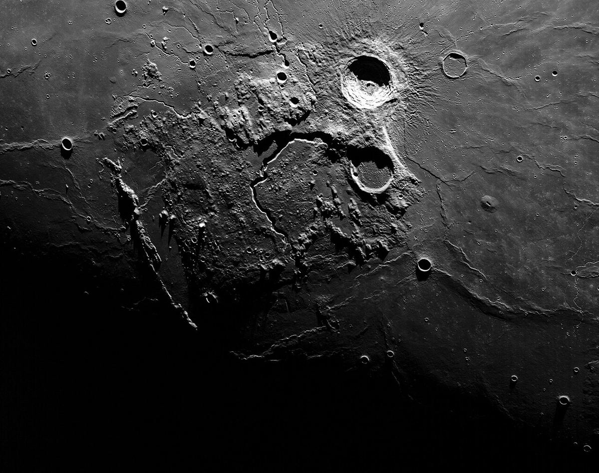 Miniatura: Pormenor da superfície da Lua junto ao terminador, com crateras e sulcos em relevo