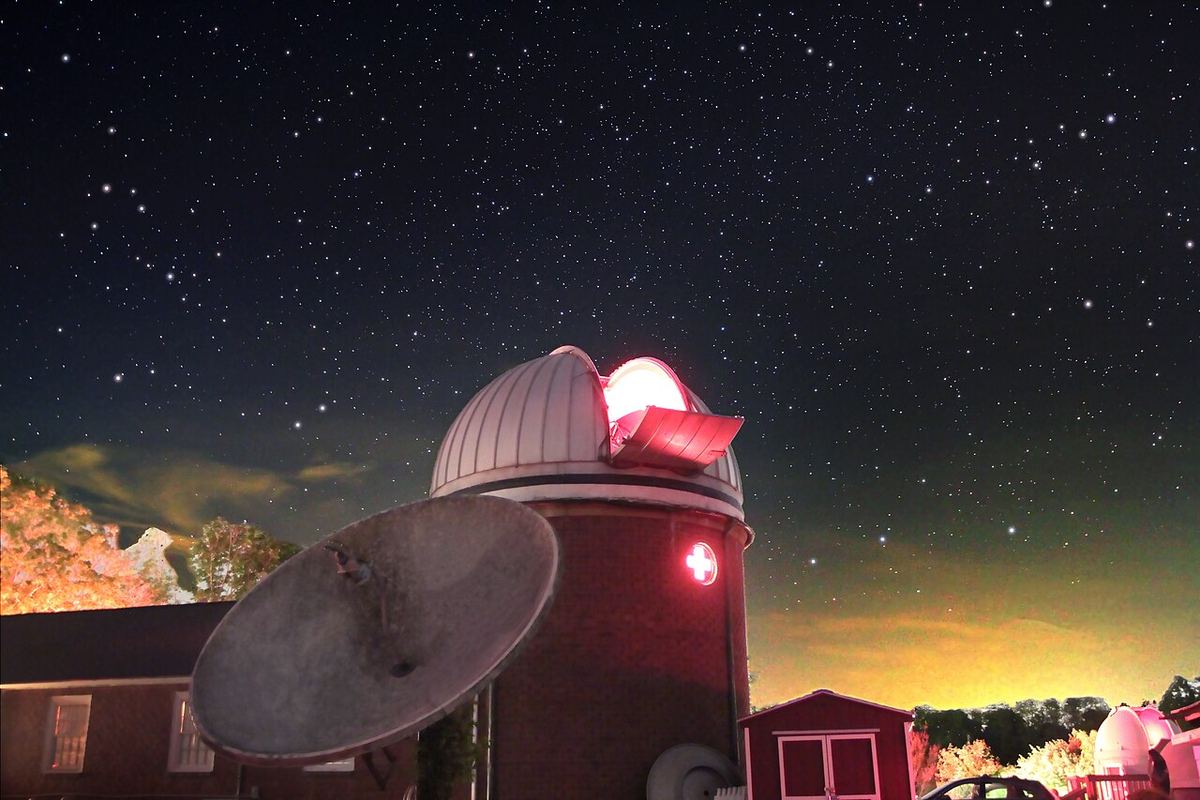 Cúpula de observatório iluminada por uma luz vermelha ao anoitecer