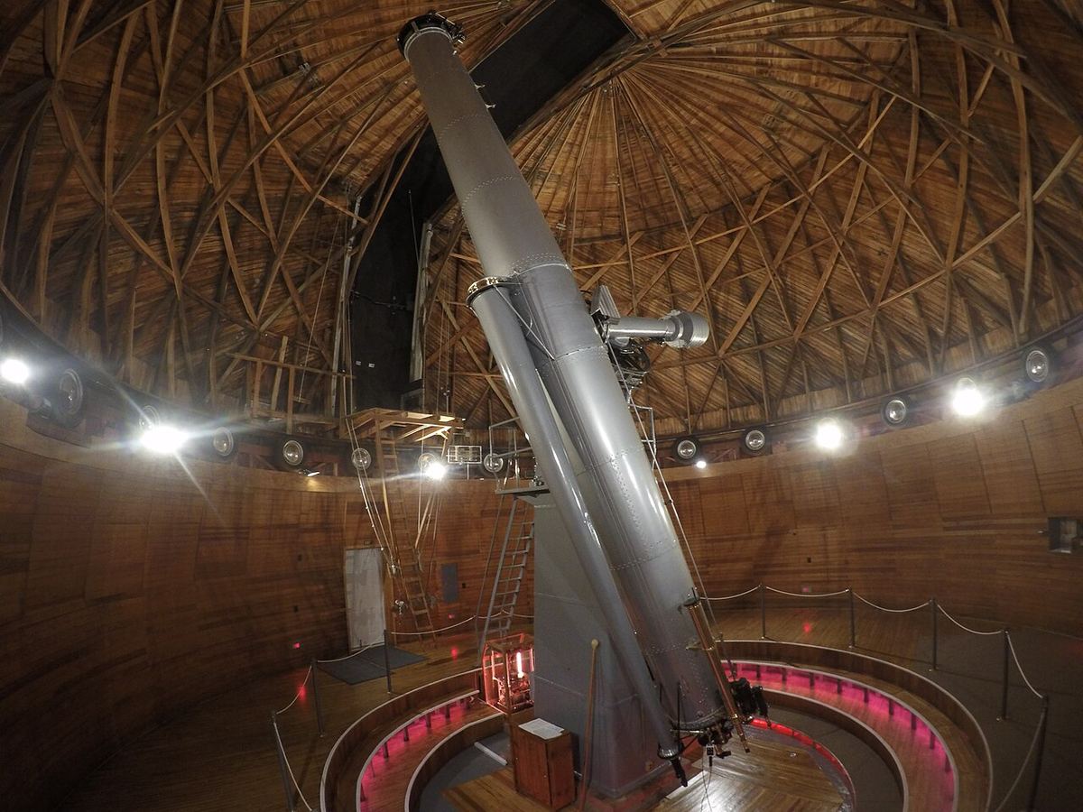 Miniatura: Grande refrator histórico dentro de uma cúpula de madeira de um observatório